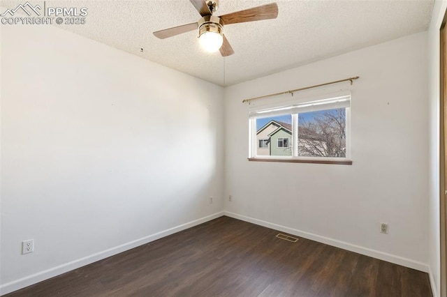 spare room featuring dark wood finished floors, visible vents, a ceiling fan, a textured ceiling, and baseboards