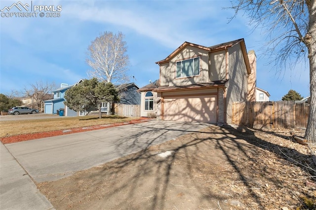 view of front of property featuring a garage, driveway, a chimney, and fence