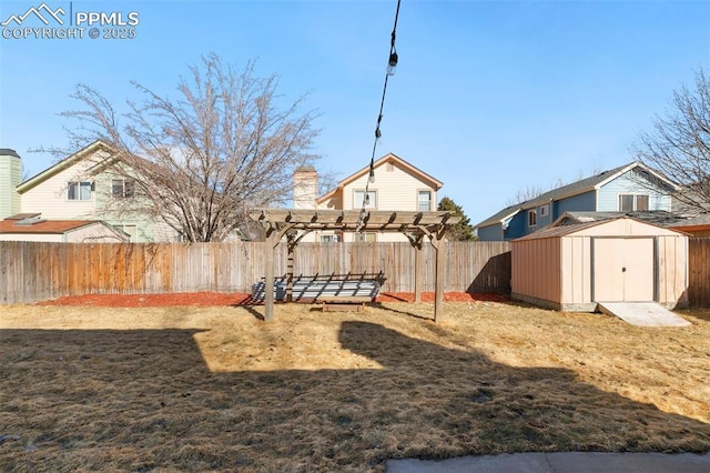 view of yard with a fenced backyard, a storage unit, a pergola, and an outbuilding