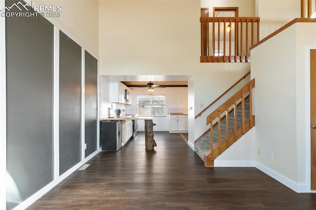 interior space featuring dark wood-style floors, stairs, and baseboards