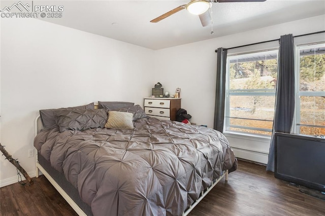 bedroom featuring dark wood-type flooring, baseboards, baseboard heating, and a ceiling fan