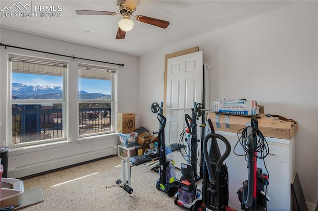 exercise area featuring a baseboard heating unit, ceiling fan, and carpet floors