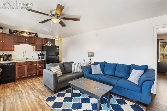 living area with a ceiling fan and light wood-style flooring