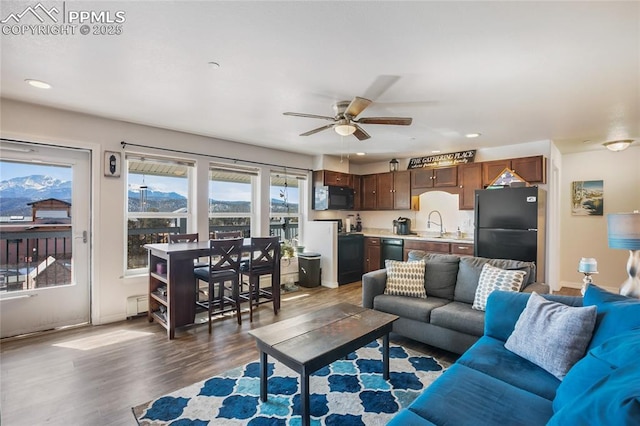 living room featuring baseboards, dark wood-type flooring, a ceiling fan, and recessed lighting