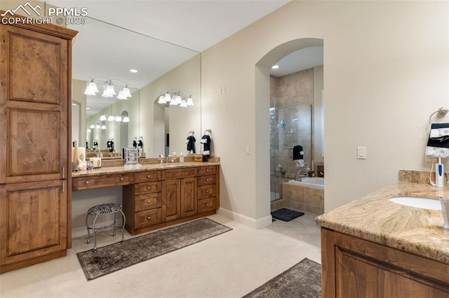 full bathroom with a stall shower, baseboards, a bath, and vanity