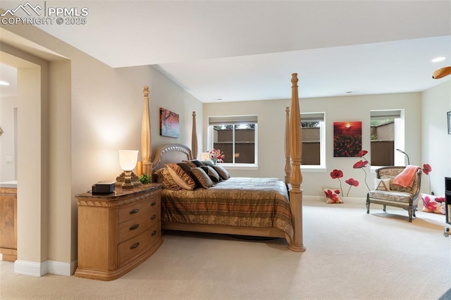 bedroom featuring light carpet and baseboards