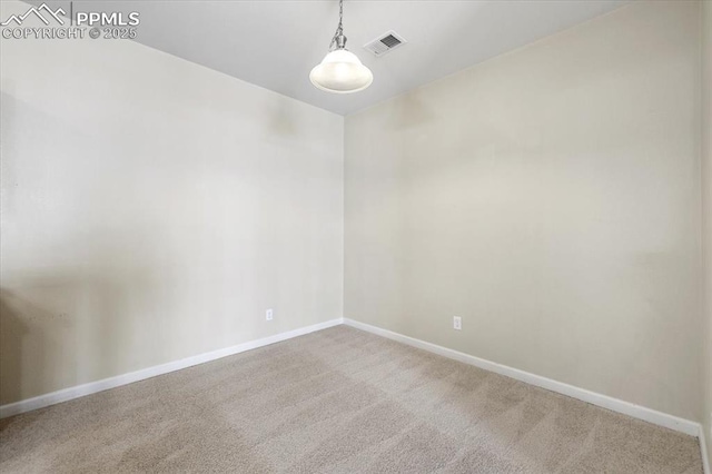 empty room with carpet floors, visible vents, and baseboards