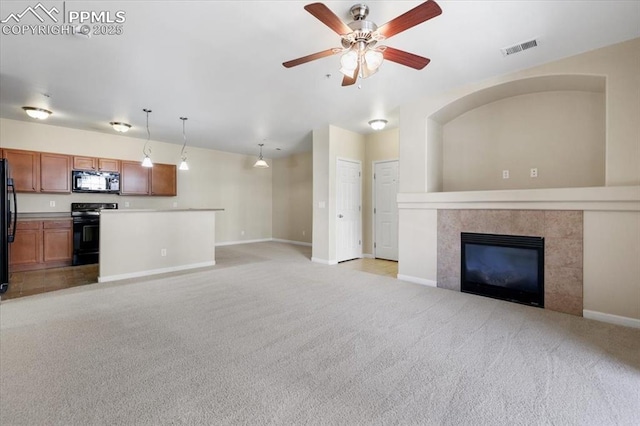 unfurnished living room with light carpet, ceiling fan, visible vents, and a tiled fireplace