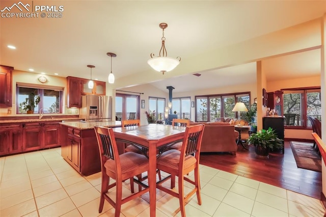 dining room with recessed lighting, a wood stove, and light tile patterned floors