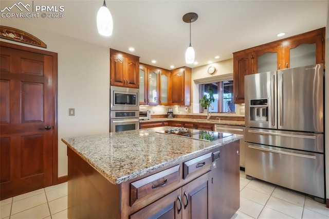 kitchen featuring light stone counters, a center island, light tile patterned floors, stainless steel appliances, and glass insert cabinets