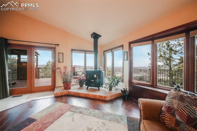 sunroom featuring a wood stove and vaulted ceiling