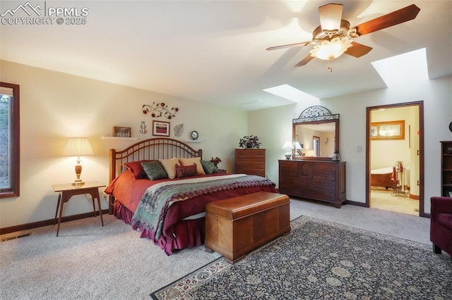 bedroom featuring a skylight, visible vents, baseboards, ceiling fan, and carpet flooring