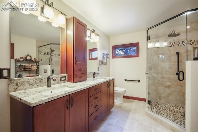 full bath featuring a stall shower, a sink, toilet, and double vanity