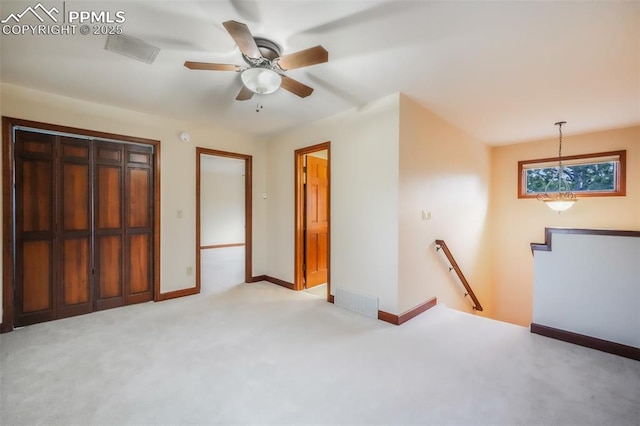 unfurnished bedroom featuring light carpet, ceiling fan, and baseboards