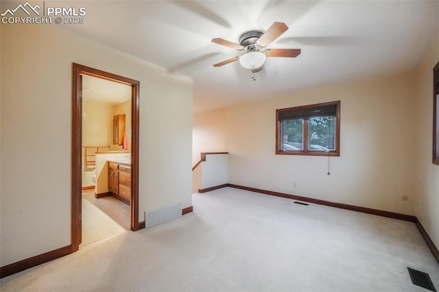 empty room with baseboards, visible vents, and light colored carpet