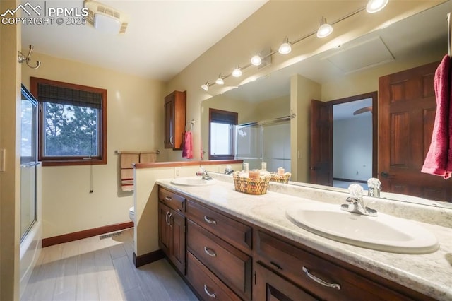 full bathroom with toilet, an enclosed shower, and a sink