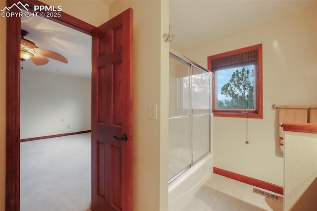 bathroom with enclosed tub / shower combo, a ceiling fan, visible vents, and baseboards