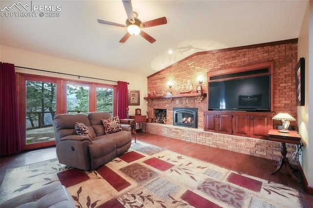 living area featuring visible vents, brick wall, wood finished floors, vaulted ceiling, and a brick fireplace