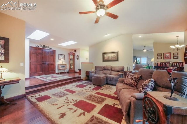 living room with ceiling fan with notable chandelier, lofted ceiling with skylight, wood finished floors, and baseboards