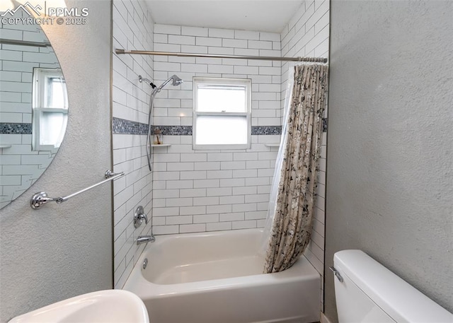 full bath featuring shower / bath combo, a textured wall, and toilet