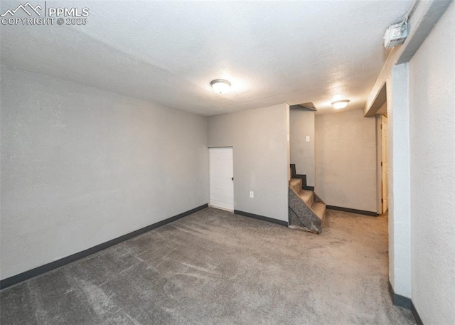 basement featuring stairs, a textured ceiling, carpet flooring, and baseboards