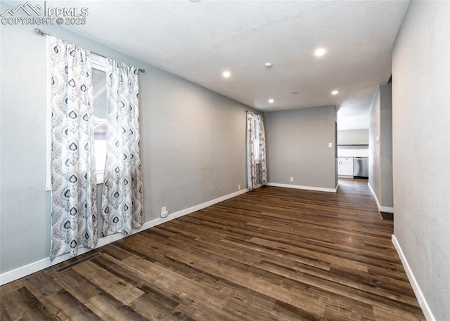 empty room featuring dark wood-style floors, baseboards, and recessed lighting