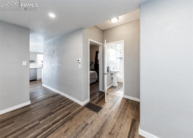 hallway with baseboards and wood finished floors