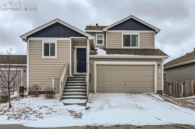 view of front of house with a garage, fence, board and batten siding, and roof with shingles