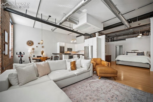 living area with a high ceiling and wood finished floors