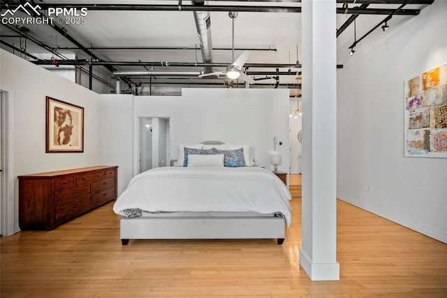 bedroom with wood finished floors and baseboards