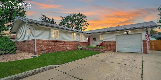 ranch-style house featuring a garage, brick siding, fence, concrete driveway, and a lawn