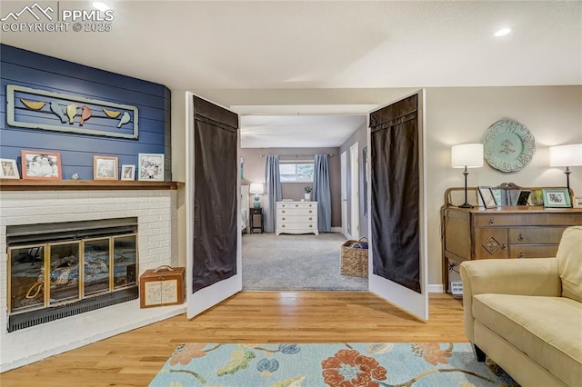 living area featuring a fireplace, wood finished floors, and baseboards