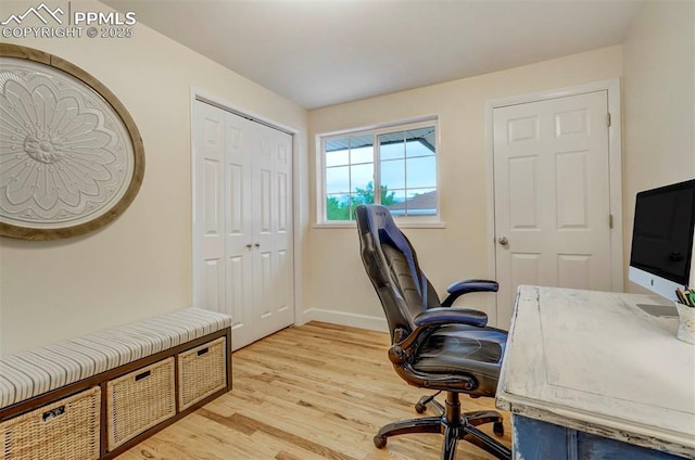 home office with light wood-type flooring and baseboards