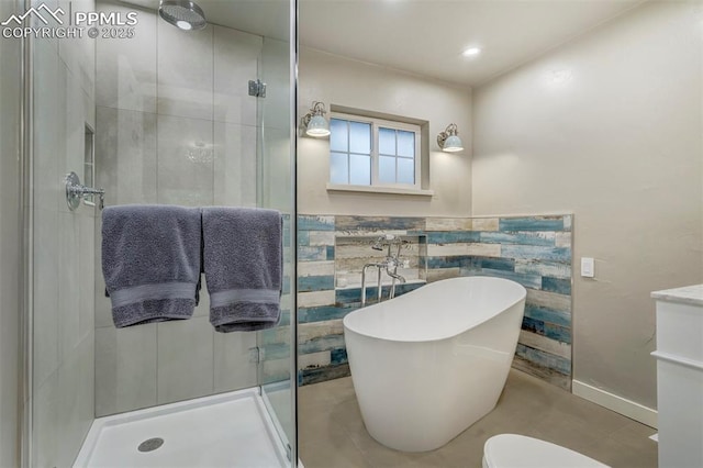 full bath featuring tile walls, a soaking tub, a shower stall, and toilet