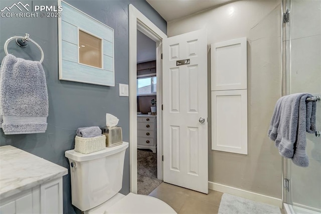 full bathroom with baseboards, toilet, tile patterned floors, vanity, and a shower stall