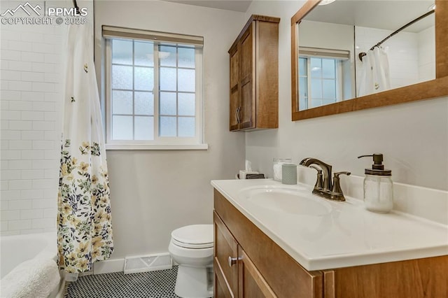 bathroom with toilet, vanity, visible vents, baseboards, and shower / bath combo