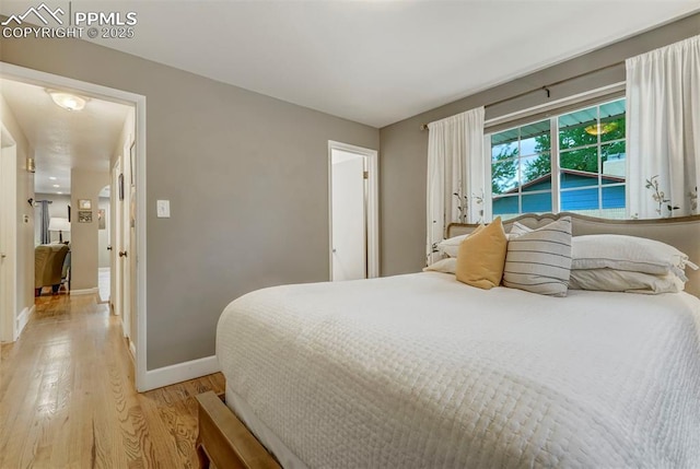 bedroom featuring light wood-style floors and baseboards