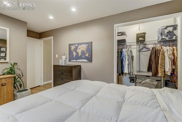 bedroom with a closet, wood finished floors, and recessed lighting