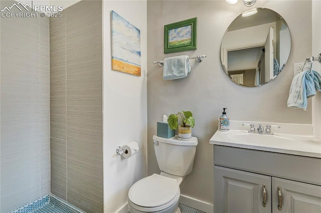 full bath with baseboards, a tile shower, vanity, and toilet