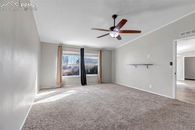 empty room with baseboards, visible vents, light colored carpet, lofted ceiling, and crown molding