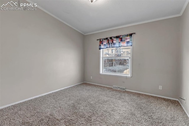 carpeted spare room with ornamental molding, visible vents, and baseboards