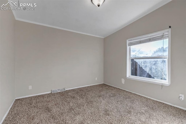 empty room featuring carpet flooring, vaulted ceiling, visible vents, and baseboards