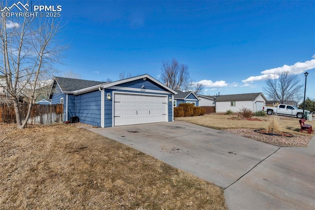 exterior space featuring a yard, driveway, an attached garage, and fence