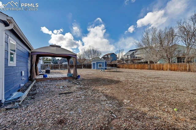 view of yard with an outbuilding, a storage unit, a gazebo, a residential view, and a fenced backyard