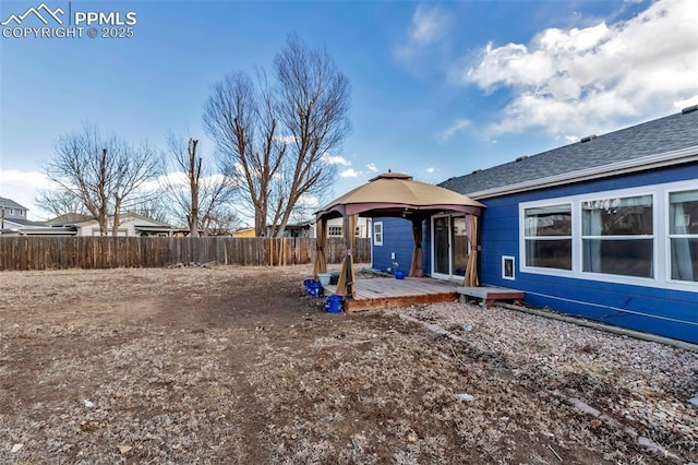 view of yard featuring fence, a deck, and a gazebo