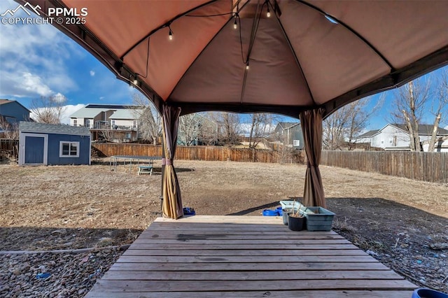 exterior space featuring a fenced backyard, an outdoor structure, a gazebo, and a shed