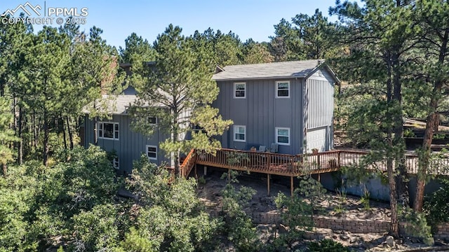 back of house featuring a garage, board and batten siding, and a wooden deck