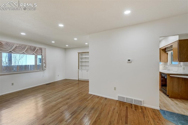 unfurnished living room with light wood-style floors, recessed lighting, visible vents, and baseboards