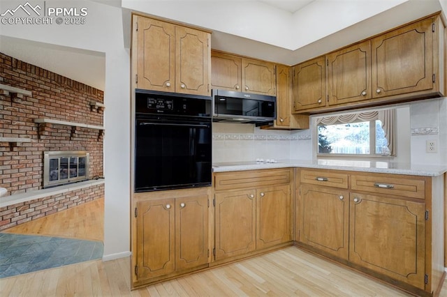 kitchen with electric stovetop, oven, light wood-style floors, light countertops, and stainless steel microwave