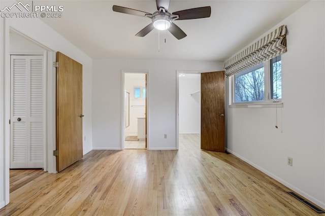 unfurnished bedroom featuring light wood finished floors, baseboards, visible vents, and a closet